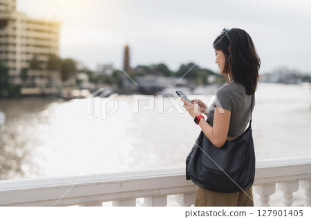 Young southeast asian woman teenager blogger world travel explorer searching smartphone map guide. Asia tourism concept local cultural experience Bangkok Thailand Chao Phraya River Young southeast asian woman teenager blogger world travel explorer searching smartphone map guide. Asia tourism concept local cultural experience Bangkok Thailand Chao Phraya River 127901405