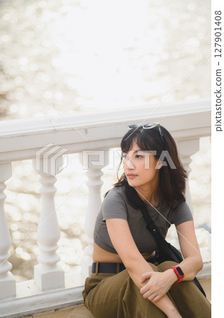 Calm young solo southeast asian woman teenager blogger on world travel tourism. An explorer local cultural experience concept in Bangkok Thailand near Chao Phraya river Asia with smartphone Calm young solo southeast asian woman teenager blogger on world travel tourism. An explorer local cultural experience concept in Bangkok Thailand near Chao Phraya river Asia with smartphone 127901408