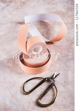 Beige special physical tapes for face and body on the table vertical view 127902504