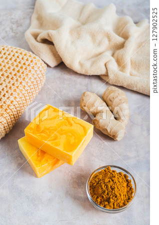Herbal turmeric soap bars and root on the table vertical view Herbal turmeric soap bars and root on the table vertical view 127902525