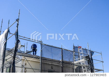 Roof repair work on a detached house - Worker 127903403