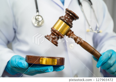 Doctor holding judge gavel, forensic medicine, medical law and crime justice. 127903472