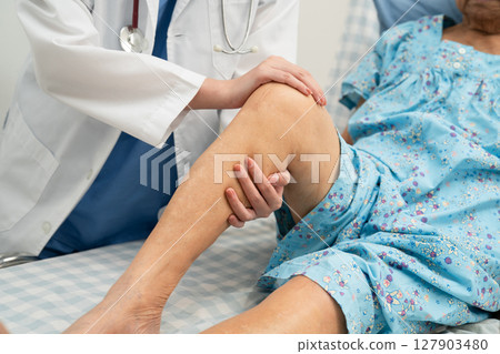 Doctor checking Asian elderly woman patient knee replacement surgery in hospital. Doctor checking Asian elderly woman patient knee replacement surgery in hospital. 127903480