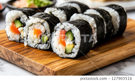 Japanese maki sushi with fish, vegetables and rice served on bamboo plate for traditional meal 127903518