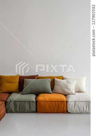 Stylish modern modular sofa with cushions in a bright white room offering ample copy space 127903582