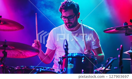 Passionate Drummer Immersed in Music with Colorful Lights 127903697