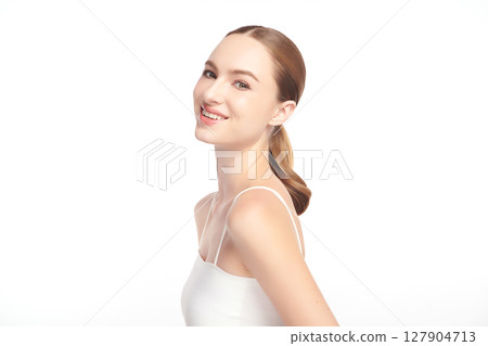 A beautiful young woman with clean, fresh skin against a white background. Skincare, facial treatment, cosmetology, beauty, and spa. An elegant portrait of an woman. 127904713