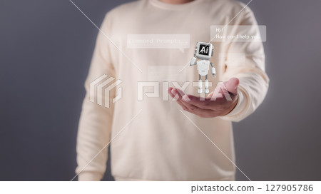 A person holding their hand out with a miniature white robot displaying AI and chat bubbles, Artificial intelligence, conversational AI, digital assistance, future technological interaction. A person holding their hand out with a miniature white robot displaying AI and chat bubbles, Artificial intelligence, conversational AI, digital assistance, future technological interaction. 127905786