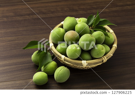 Unripe plums in a colander 127906225