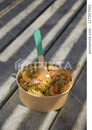 tricolor pasta on a shaded picnic table tricolor pasta on a shaded picnic table 127907002