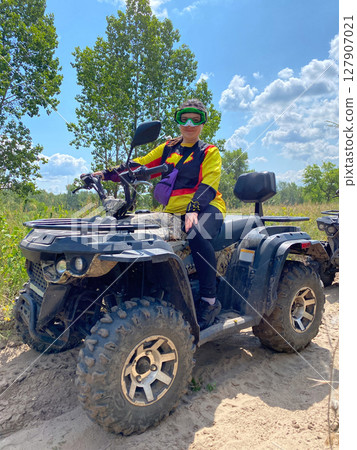 Quad bike ride on dirt roads in nature, vertical shooting 127907021