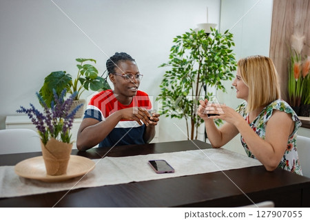 Friends enjoying a warm conversation over tea at a cozy caf 127907055
