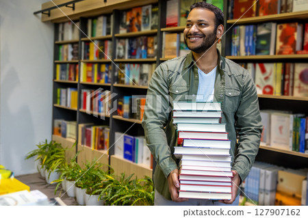 Young african american man carrying a pile of books 127907162