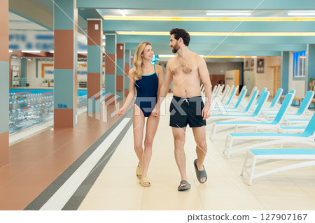Young cute couple in swimwear in the swimming pool 127907167