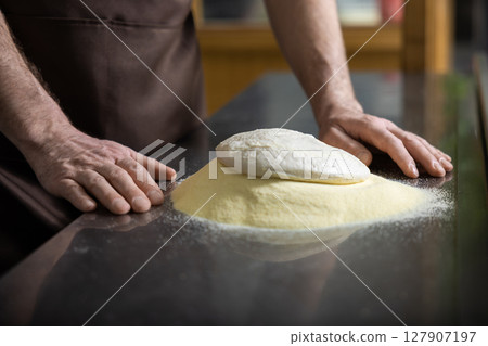 Close up of mans hands kneading dough for preparing pizza 127907197