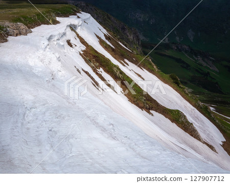 Snowfield on stony mountain ridge Snowfield on stony mountain ridge 127907712