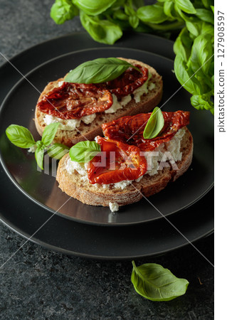 Tasty ciabatta with sun dried tomatoes in olive oil, ricotta and basil. Tasty ciabatta with sun dried tomatoes in olive oil, ricotta and basil. 127908597