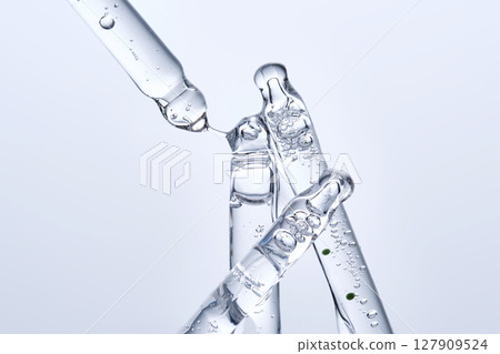 Four different face serum pipettes on a neutral background. 127909524