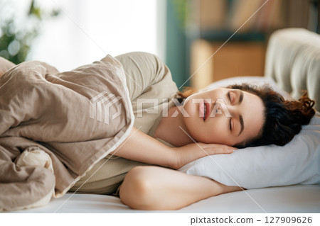 Woman is sleeping in her bedroom 127909626