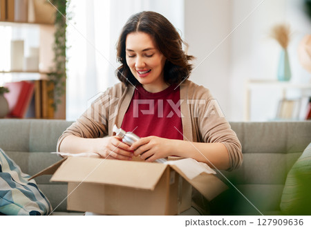 Woman is unpacking cardboard 127909636