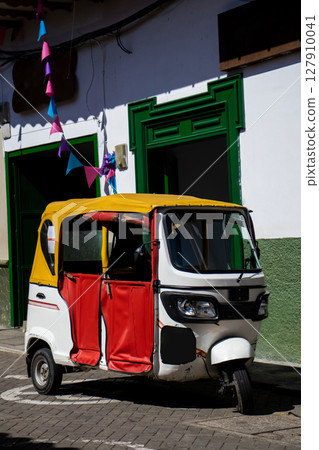 Motor tricycle at the beautiful streets of the Heritage Town of Jerico located in the Department of Antioquia in Colombia. 127910041