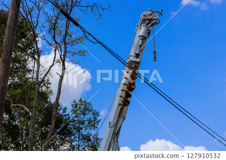 Utility operator truck to maintain power lines during electrician workers use an auger 127910532