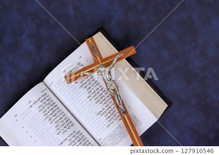24 April 2025 Jerusalem Israel Wooden crucifix atop an open Hebrew Holy Bible symbolizes faith reflection in Messianic Jewish Congregation during prayer time "Hebrew Tanakh prayer holy book" 127910546