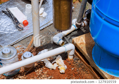 Work area artesian water well plumbing tools, pipes, materials being prepared for repairs 127910559