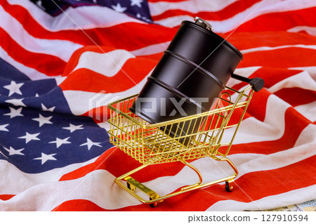 Golden shopping cart holds black barrel top vibrant American flag 127910594