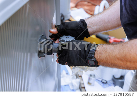 Skilled technician is adjusting mechanical valve filter system to swimming pool 127910597