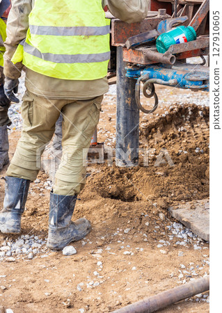 Close-up of soil sampling during pile drilling process. Extraction of subsurface material for geotechnical analysis and foundation assessment 127910605
