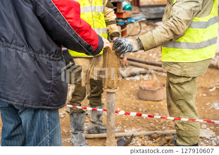 Man cutting and cleaning soil sample for laboratory analysis. Preparation of core material for geotechnical testing and scientific evaluatio 127910607