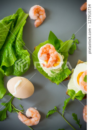 Appetizing breakfast with shrimp, egg and greens from above Appetizing breakfast with shrimp, egg and greens from above 127910734