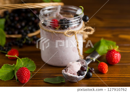 Blackcurrant ice cream with strawberries on wooden background Blackcurrant ice cream with strawberries on wooden background 127910762