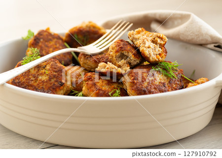 Delicious fried cutlets in a baking dish on a white table 127910792