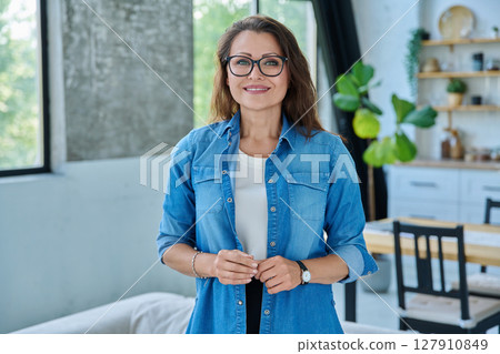 Portrait confident middle aged woman posing in home Portrait confident middle aged woman posing in home 127910849