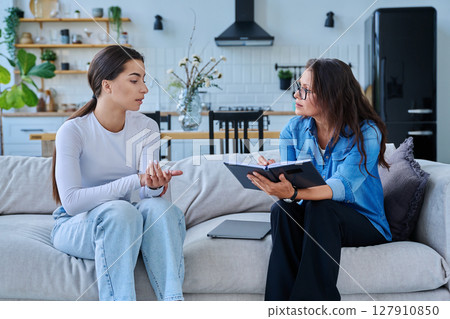 Female social worker working at home with teenage girl 127910850