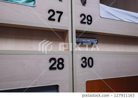Numbered capsule hotel rooms offering privacy and comfort Numbered capsule hotel rooms offering privacy and comfort 127911163