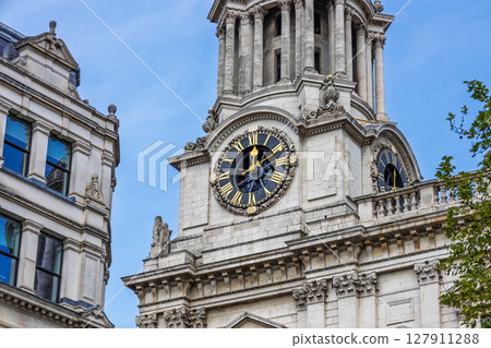 St Pauls Cathedral clock tower in London against clear blue summer sky, baroque stone St Pauls Cathedral clock tower in London against clear blue summer sky, baroque stone 127911288
