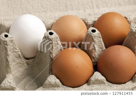 Close-up view of raw chicken eggs brown and white in a box, egg white, egg 127911455