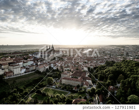 Soft morning light bathes Prague Castle and the surrounding cityscape in golden hues. Serenity fills the air as day breaks over this historic landmark, inviting exploration. Soft morning light bathes Prague Castle and the surrounding cityscape in golden hues. Serenity fills the air as day breaks over this historic landmark, inviting exploration. 127911981