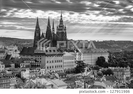 The first light of dawn casts a soft glow over Prague Castle, highlighting its majestic towers. The city awakens as sunlight breaks through the clouds, creating a magical atmosphere. The first light of dawn casts a soft glow over Prague Castle, highlighting its majestic towers. The city awakens as sunlight breaks through the clouds, creating a magical atmosphere. 127911986