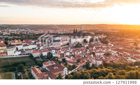 Golden sunrise casts warm light over Prague Castle, illuminating the historic buildings and rooftops of the city. A tranquil morning reveals the beauty of Praha and its rich architecture. Golden sunrise casts warm light over Prague Castle, illuminating the historic buildings and rooftops of the city. A tranquil morning reveals the beauty of Praha and its rich architecture. 127911998