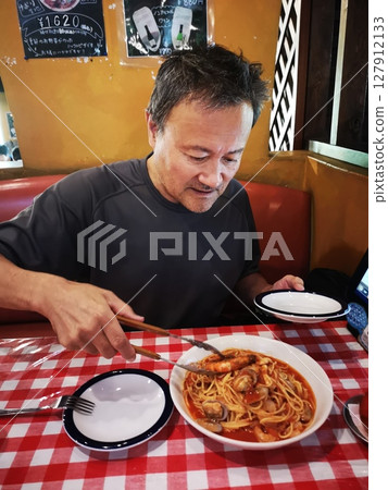 一位老人在義大利餐廳吃漁夫式義大利麵 一位老人在義大利餐廳吃漁夫式義大利麵 127912133
