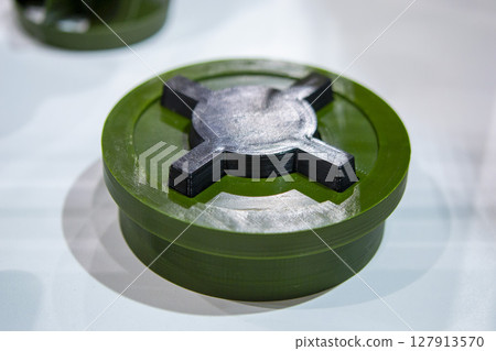 Anti-personnel high explosive mine printed on 3D printer. Mine created on 3D printer from molten plastic. Prototype of ammunition printed on 3D printer. Innovation modern new 3d printing technology Anti-personnel high explosive mine printed on 3D printer. Mine created on 3D printer from molten plastic. Prototype of ammunition printed on 3D printer. Innovation modern new 3d printing technology 127913570