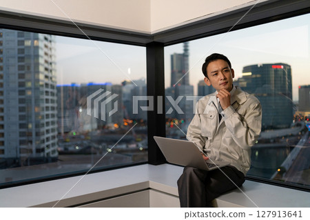 一名身穿工作服的男子在辦公室操作電腦 127913641
