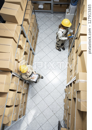 Retail supply chain operations ensured by diverse employees to manage depot inventory, organizing products and coordinating shipment using logistics systems and barcode tracking. 127913885