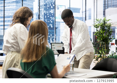 Job interview candidate walking with crutches interested in career advancement, talking with team of HR experts. Man using canes discussing with human resources colleagues to get hired 127913995