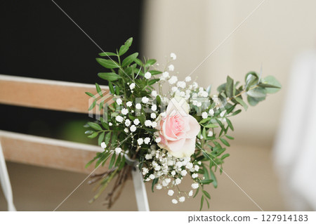 Guest chairs decorated with small bouquets for outdoor wedding ceremony Guest chairs decorated with small bouquets for outdoor wedding ceremony 127914183