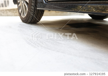 Tire marks left on the concrete floor of a parking lot 127914195